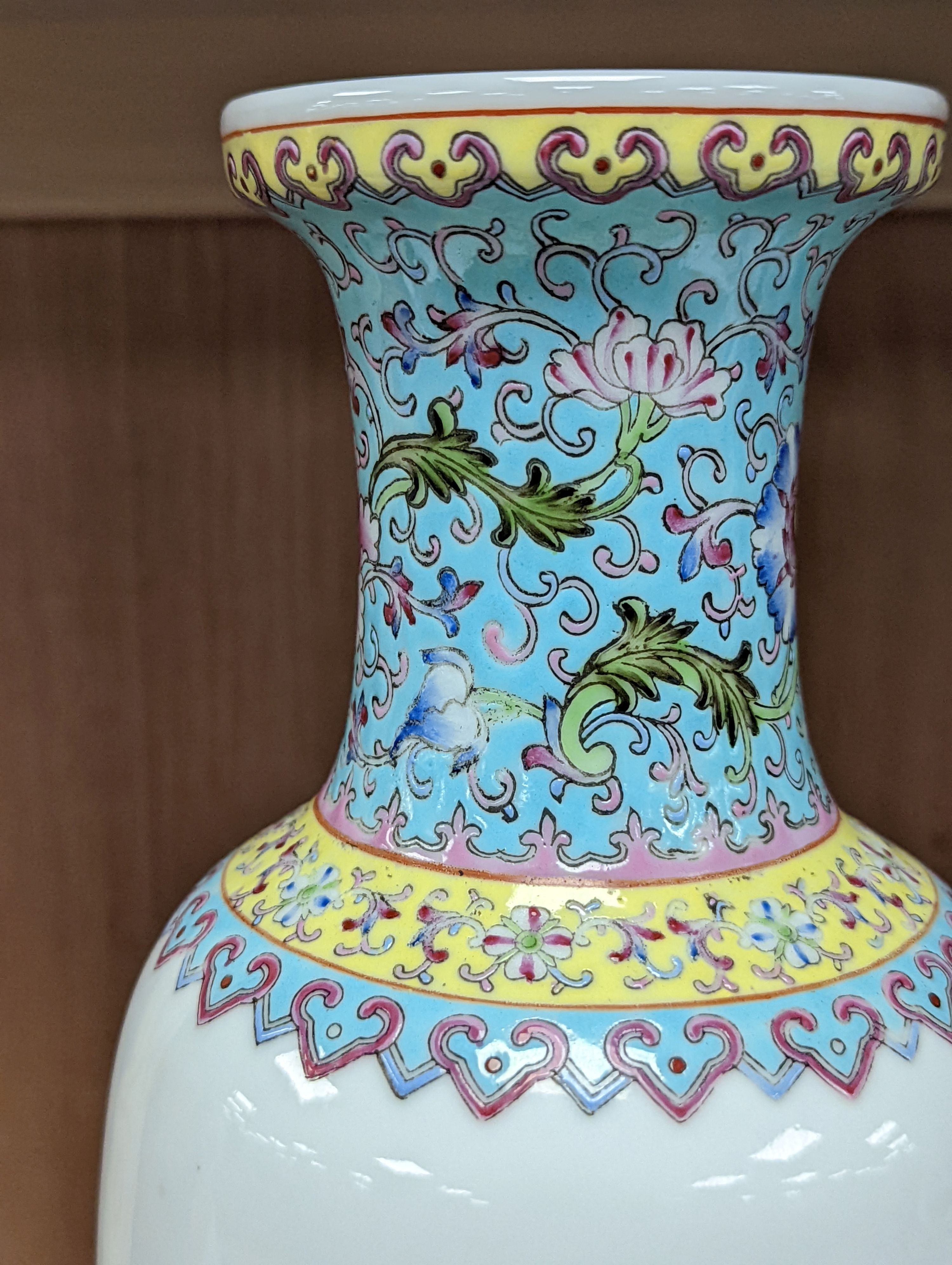 A pair of Chinese famille rose vases decorated with peacocks, 31cm